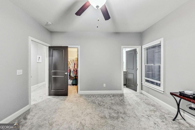 bedroom with carpet floors, a walk in closet, a closet, and baseboards