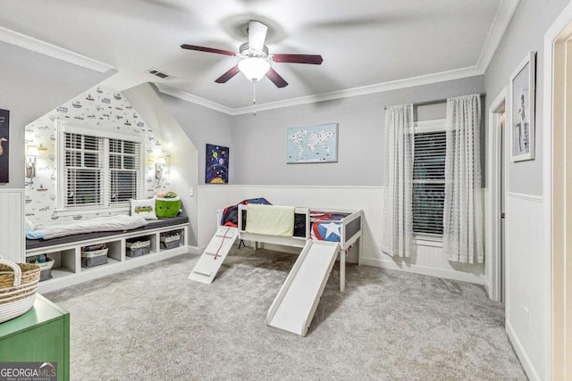 bedroom with a wainscoted wall, carpet, visible vents, and crown molding