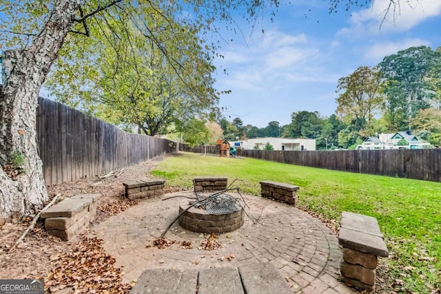 view of patio / terrace featuring a fire pit, a playground, and a fenced backyard