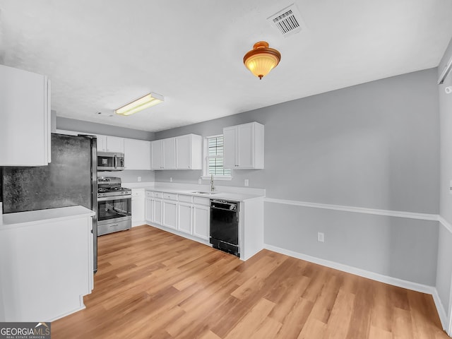 1681 Graystone Dr, Hampton, GA 30228 - kitchen with appliances with stainless steel finishes, white cabinets, and light wood-style flooring