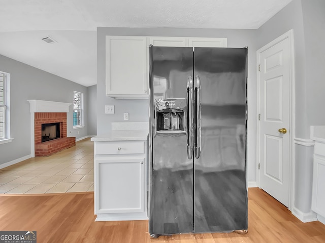 1681 Graystone Dr, Hampton, GA 30228 - kitchen featuring fridge with ice dispenser, white cabinetry, light countertops, and light wood-type flooring