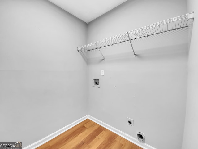 laundry room featuring laundry area, baseboards, light wood-style flooring, hookup for a washing machine, and electric dryer hookup