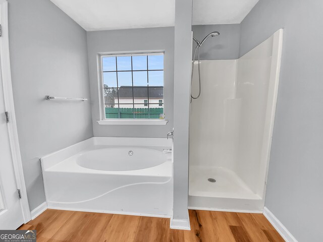 1681 Graystone Dr, Hampton, GA 30228 - bathroom with wood finished floors, a bath, and a shower
