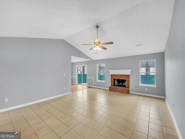 unfurnished living room featuring lofted ceiling, visible vents, a ceiling fan, a brick fireplace, and light tile patterned flooring