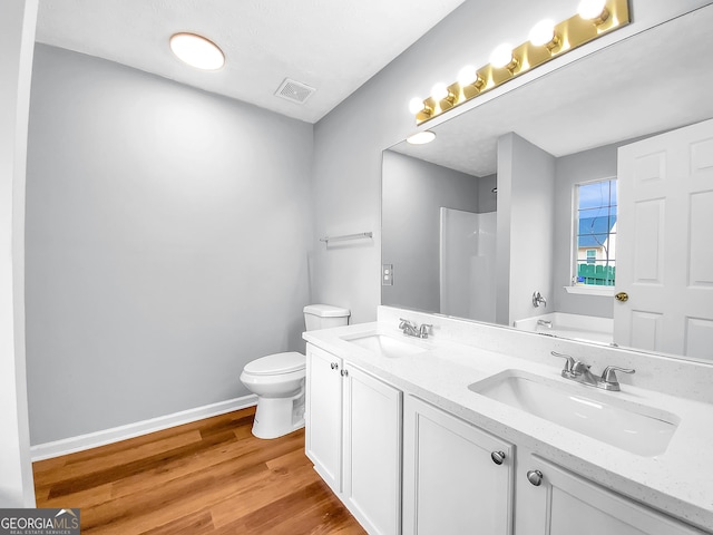 full bathroom featuring toilet, wood finished floors, a sink, and visible vents