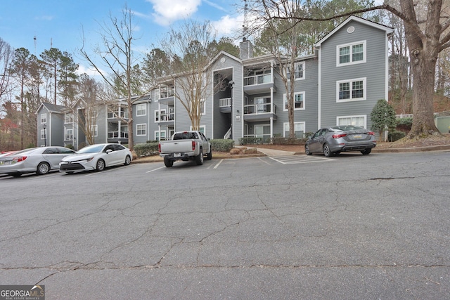 view of property with a residential view and uncovered parking