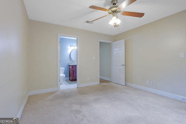 unfurnished bedroom featuring visible vents, ceiling fan, baseboards, light carpet, and ensuite bath