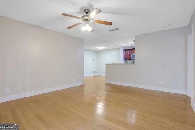 spare room with visible vents, baseboards, light wood-style floors, and a ceiling fan