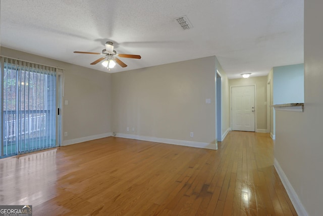 unfurnished room featuring visible vents, baseboards, light wood-type flooring, a textured ceiling, and a ceiling fan