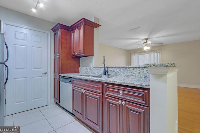 kitchen featuring a sink, dark brown cabinets, a ceiling fan, and stainless steel appliances