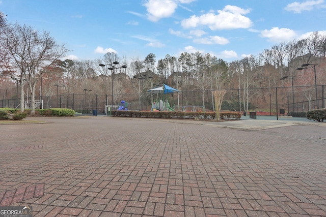 view of property's community with playground community and fence