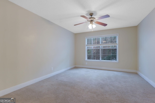 empty room with light carpet, baseboards, and ceiling fan