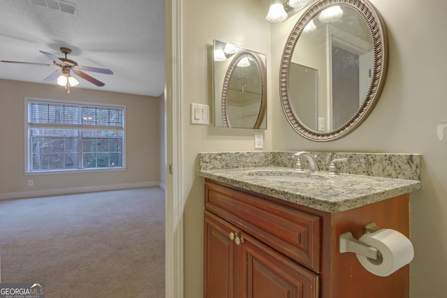 bathroom featuring visible vents, a ceiling fan, a textured ceiling, baseboards, and vanity