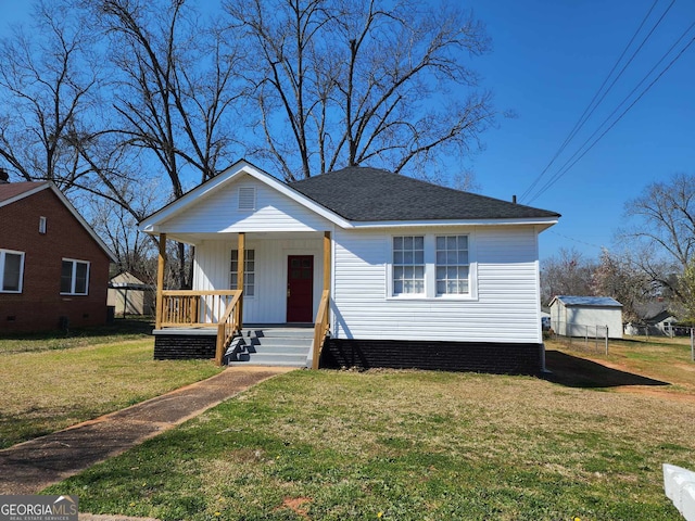 bungalow featuring roof with shingles, a porch, and a front yard