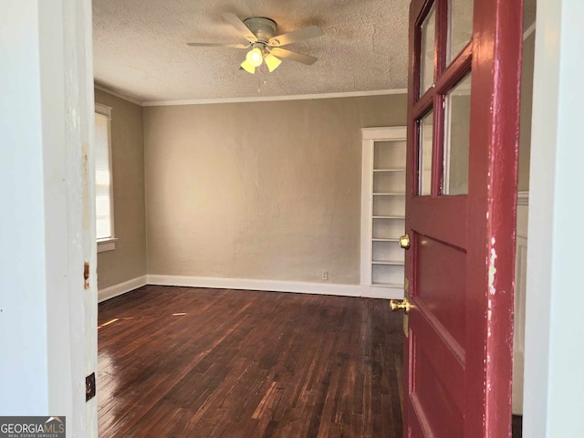 spare room featuring wood-type flooring, a textured ceiling, ceiling fan, and crown molding