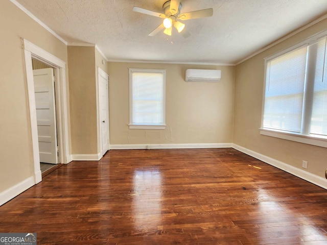 unfurnished room with a wall mounted AC, wood finished floors, and crown molding