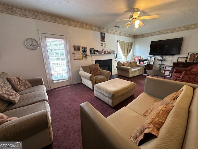 5546 Wellborn Creek Dr, Lithonia, GA 30058 - living room with dark carpet, ceiling fan, a fireplace, and a textured ceiling