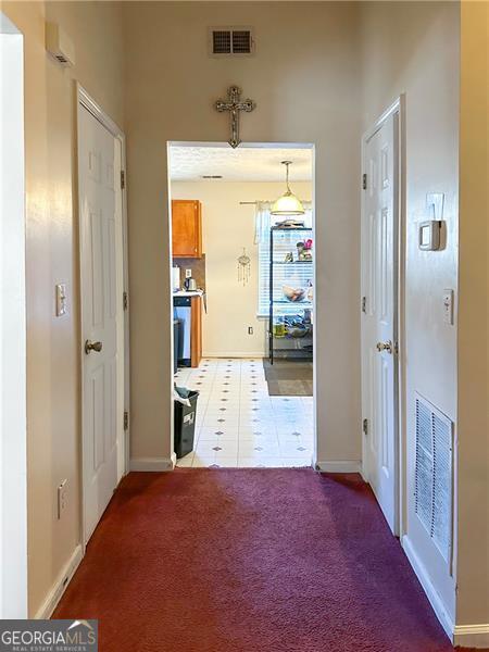 5546 Wellborn Creek Dr, Lithonia, GA 30058 - hall with baseboards, light colored carpet, and light tile patterned floors
