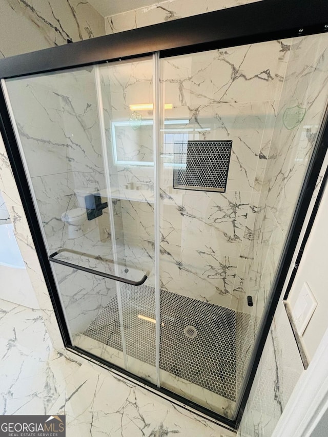 bathroom featuring marble finish floor and a marble finish shower