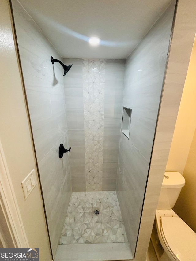 bathroom featuring toilet and a shower stall