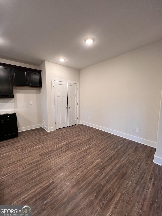 interior space featuring baseboards, dark wood-type flooring, and recessed lighting