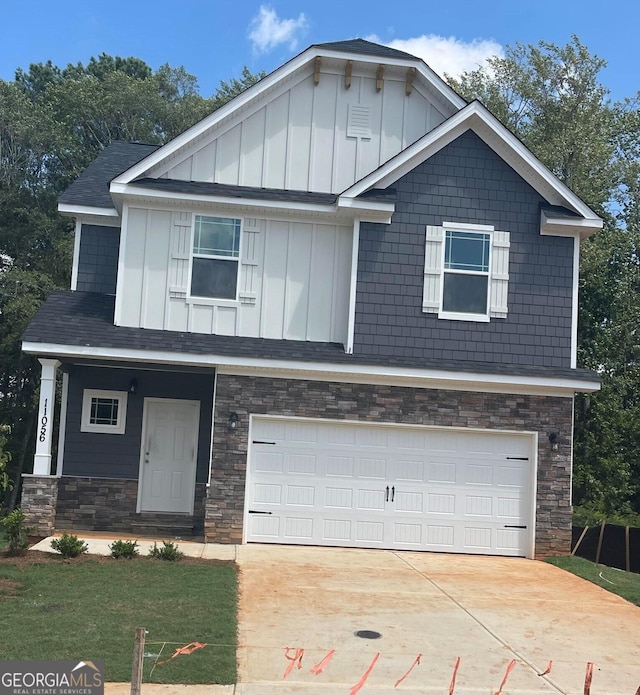 craftsman house with a shingled roof, concrete driveway, an attached garage, board and batten siding, and stone siding