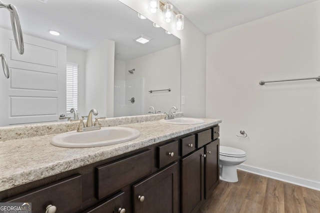 bathroom with toilet, walk in shower, a sink, and wood finished floors