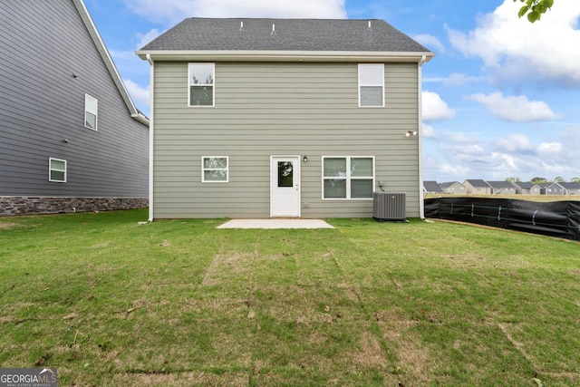 rear view of house with a patio, central AC unit, a lawn, and fence