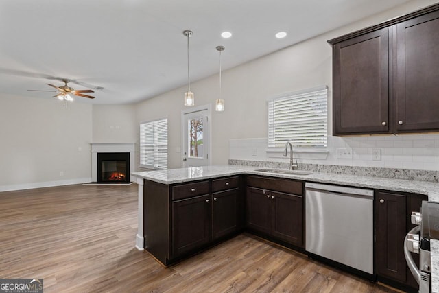 kitchen featuring ceiling fan, dark brown cabinets, a sink, dishwasher, and a peninsula