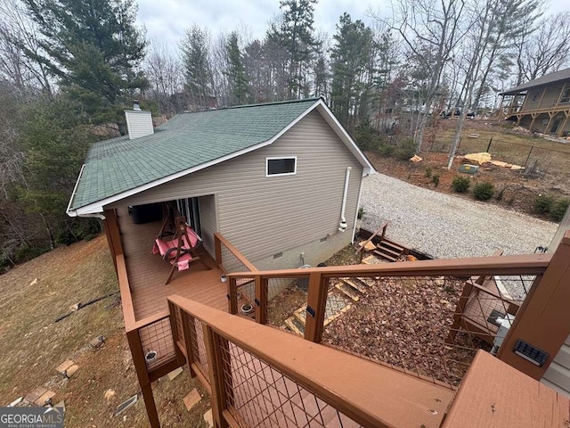 exterior space featuring crawl space, a shingled roof, a chimney, and a wooden deck