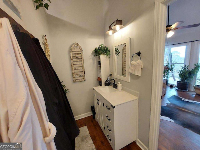 bathroom with baseboards, a ceiling fan, wood finished floors, and vanity