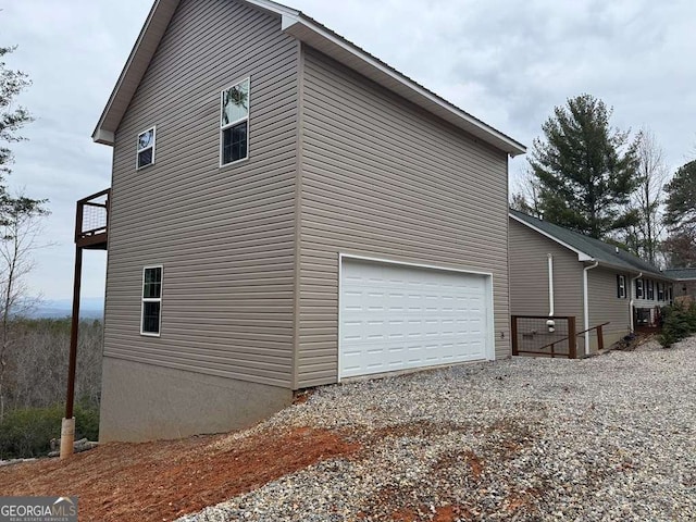 view of home's exterior with gravel driveway and an attached garage