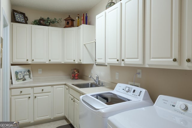 laundry area with separate washer and dryer, a sink, and cabinet space