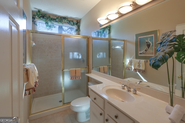 bathroom featuring toilet, a shower stall, tile patterned flooring, and vanity