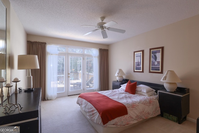 carpeted bedroom with access to outside, a textured ceiling, and a ceiling fan