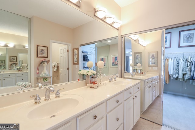 bathroom with tile patterned flooring, double vanity, and a spacious closet
