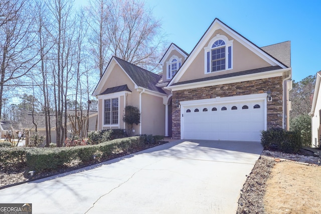 view of front facade with driveway, stone siding, a garage, and stucco siding