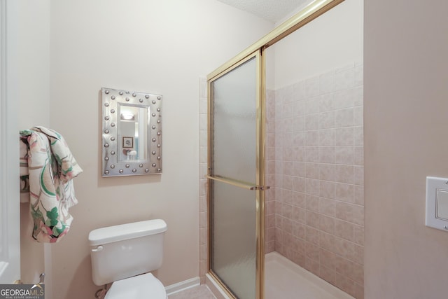 full bathroom featuring a stall shower and toilet