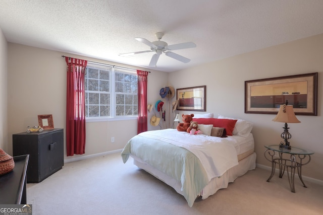 bedroom featuring a textured ceiling, baseboards, a ceiling fan, and light colored carpet