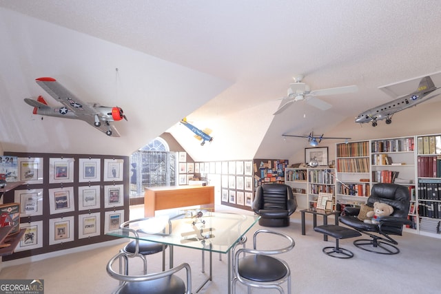sitting room featuring carpet flooring, vaulted ceiling, a ceiling fan, and an office area