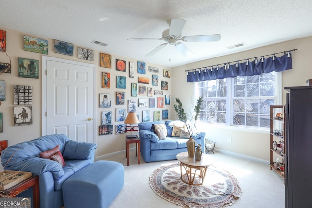 carpeted living room with ceiling fan, a textured ceiling, and baseboards