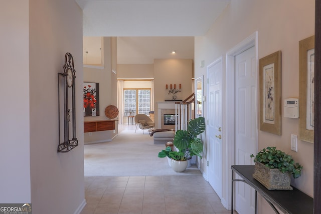 entrance foyer with light carpet, light tile patterned floors, and a tiled fireplace