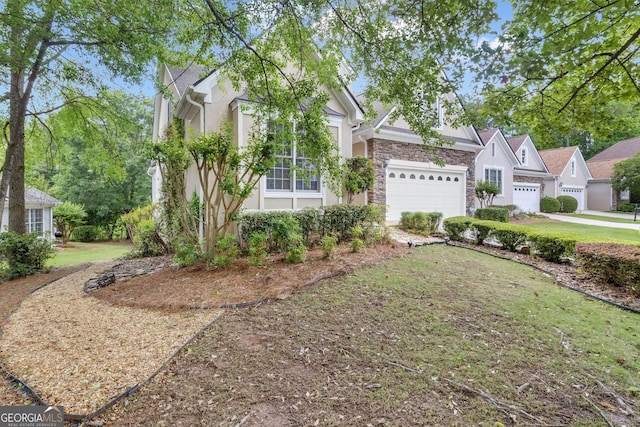 view of front of home with stucco siding, stone siding, an attached garage, and a front yard