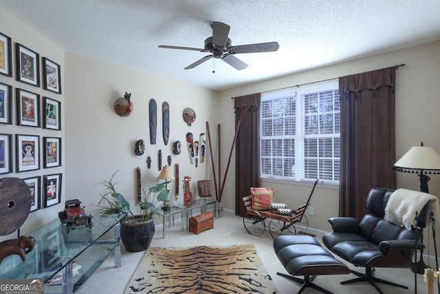living area with carpet floors, ceiling fan, a textured ceiling, and baseboards