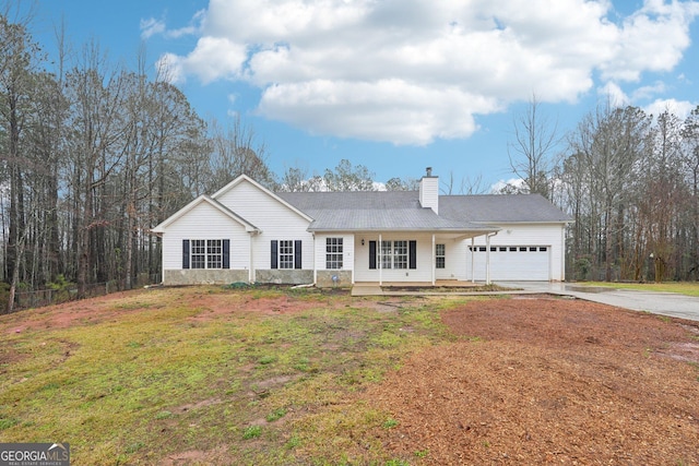 ranch-style home with driveway, covered porch, a front yard, a garage, and a chimney