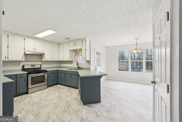 kitchen featuring stainless steel gas range oven, gray cabinetry, under cabinet range hood, a sink, and a chandelier