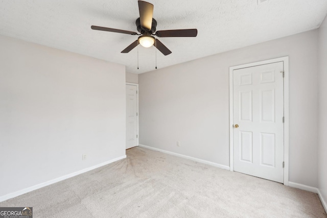 unfurnished bedroom with baseboards, carpet, a ceiling fan, and a textured ceiling