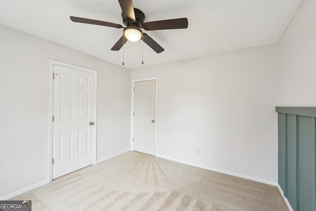 unfurnished bedroom featuring baseboards, carpet, and a ceiling fan