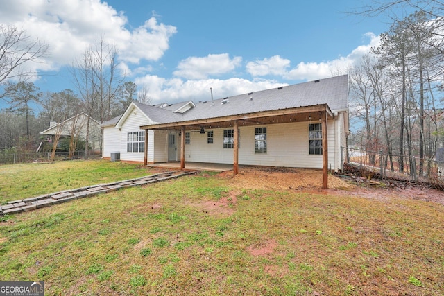 rear view of house featuring a lawn, a patio, and fence