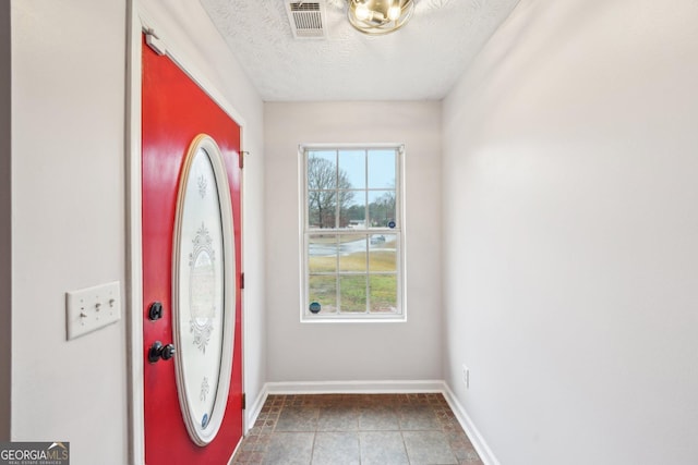 entryway with visible vents, baseboards, and a textured ceiling